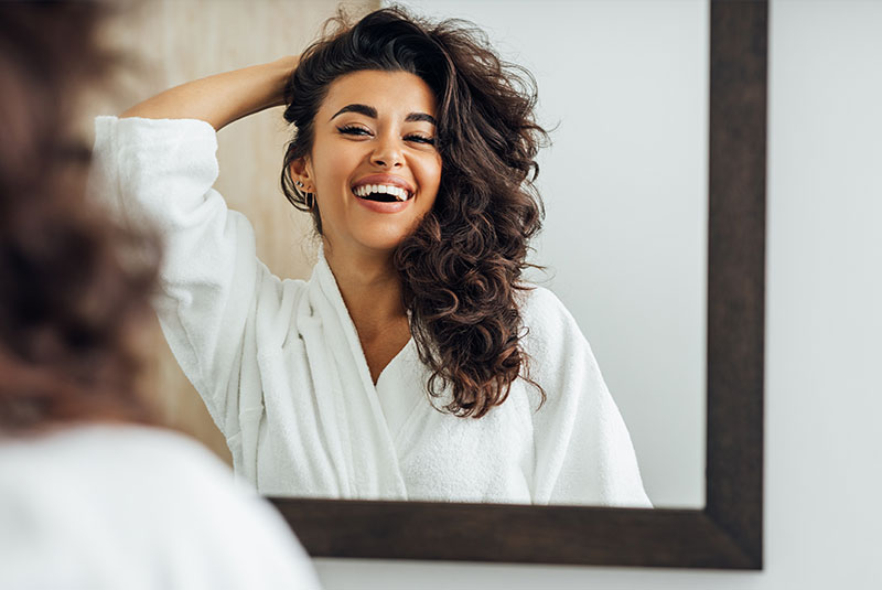 cosmetic dentistry patient smiling in mirror