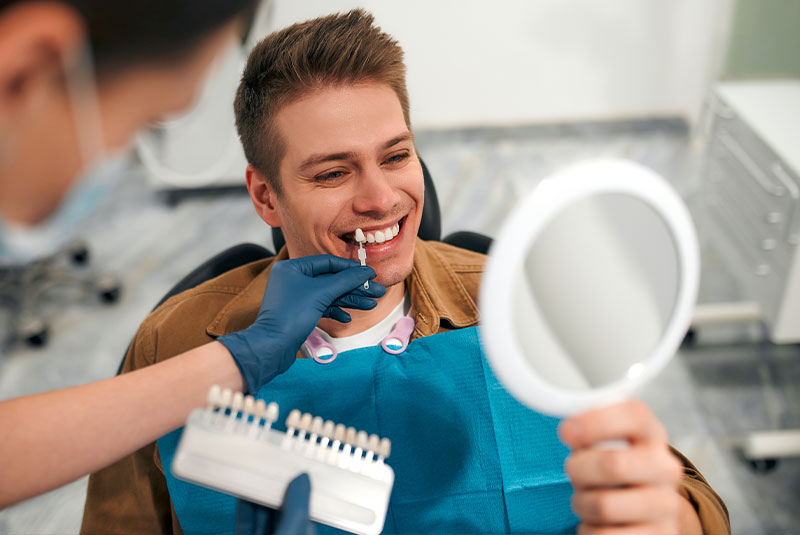 dentist showing patient different types of veneers